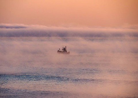 気嵐の中に出航する漁船